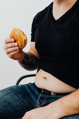 un homme tient un burger dans sa main