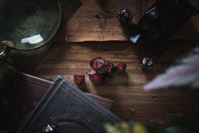 dés de jeu de rôle avec livres et loupes sur table en bois