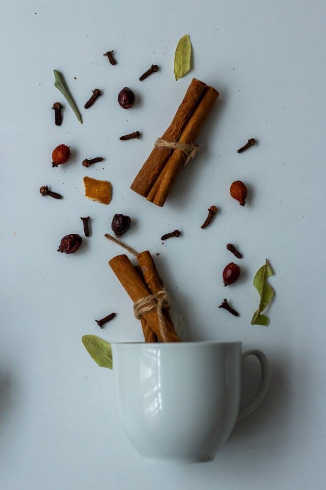 Bâtonnets de cannelle au-dessus et dans tasse à café blanche