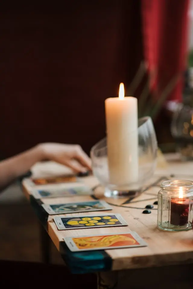 Cartes tarot avec bougies et main qui touche  une carte